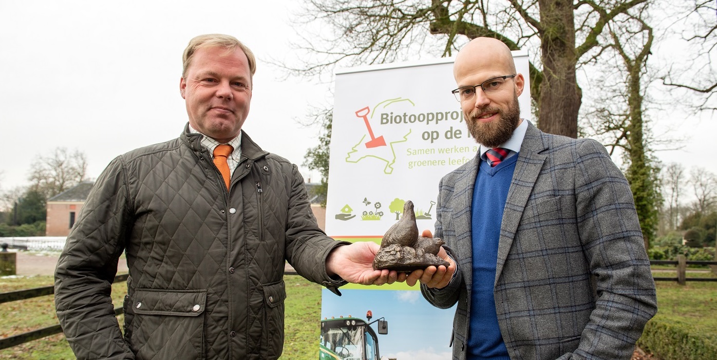 Laurens Hoedemaker (l) overhandigt patrijzenbeeldje aan rentmeester Egbert-Jaap Mooiweer van landgoed Twickel