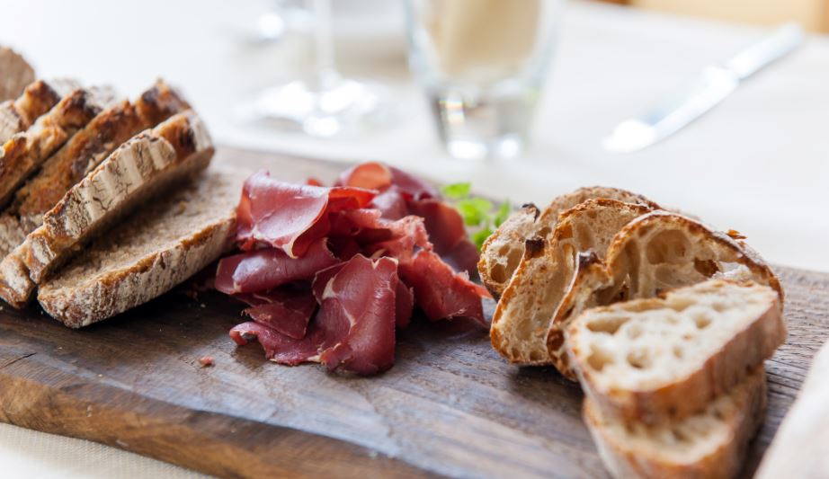 vermarkt ganzenvlees: Plank met gerookte ganzenborst en brood (c) Totally Eye Photography